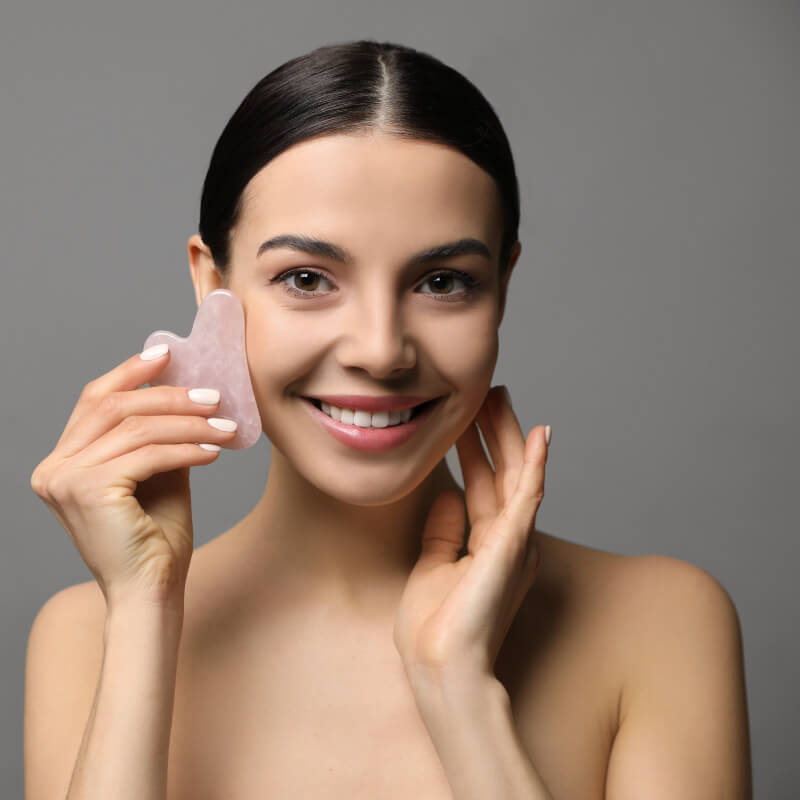 Image of a woman putting a facial plate to her face and smiling